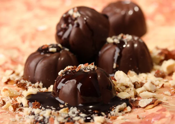 Chocolade snoepjes met noten, op een achtergrond met kleur — Stockfoto