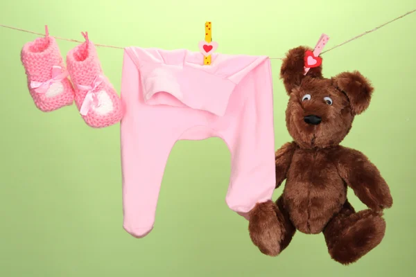 Dětské oblečení na prádelní šňůru na barvu pozadí — Stock fotografie