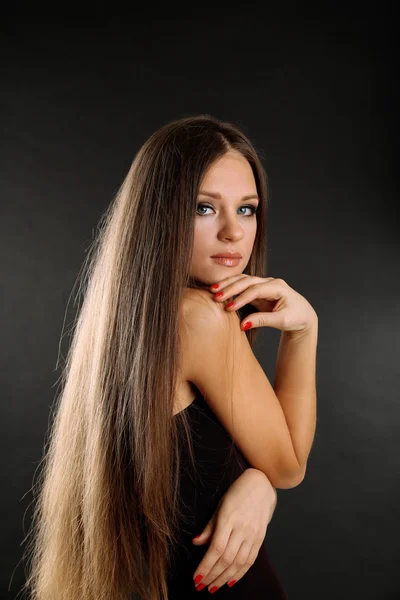 Portrait of beautiful woman with long hair on black background — Stock Photo, Image