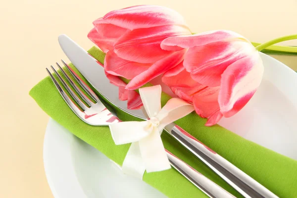 Накрытие праздничного обеденного стола с тюльпанами на бежевом фоне — стоковое фото