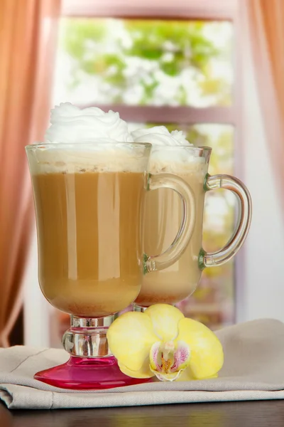 Fragrant coffee latte in glasses cups with vanilla pods, on table in cafe — Stock Photo, Image