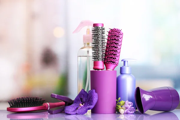 Hair brushes, hairdryer, straighteners and cosmetic bottles in beauty salo — Stock Photo, Image