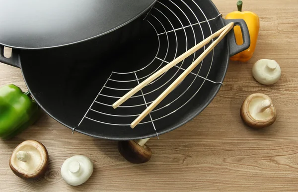Padella wok nero e verdure sul tavolo della cucina, da vicino — Foto Stock