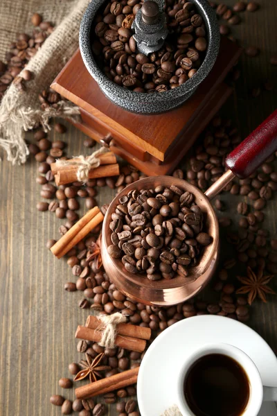 Чашка кофе, горшок и молоть на деревянном фоне — стоковое фото