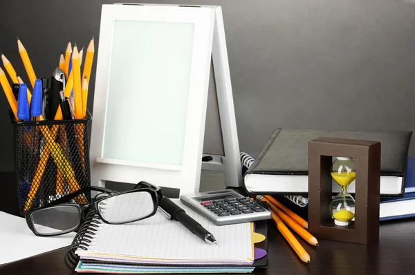 灰色の背景上のオフィスの机の上の白いフォト フレーム — ストック写真