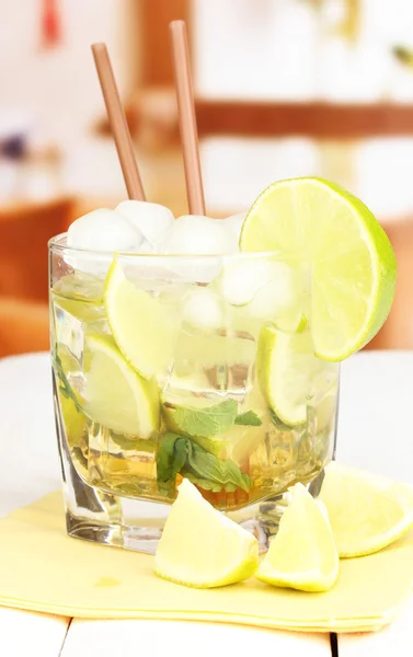 Glass of cocktail with lime and mint on white wooden table on bright background — Stock Photo, Image