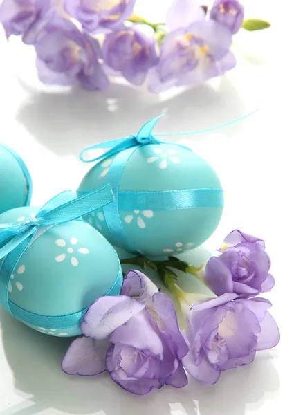 Яскраві великодні яйця з бантами і квітами, ізольовані на білому — стокове фото