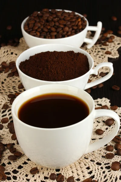 Diferentes tipos de café em três xícaras em mesa de madeira — Fotografia de Stock