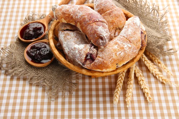 Smaka croissanter i korg och sylt på tableclot — Stockfoto