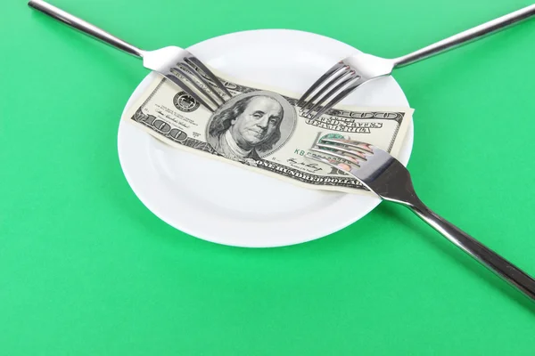 Money on plate on green background — Stock Photo, Image