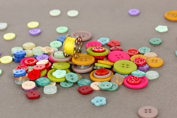 Buttons of different shapes, sizes and colors close-up on gray background — Stock Photo, Image