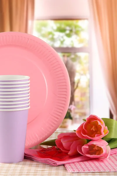 Multicolored plastic tableware on window background — Stock Photo, Image