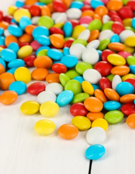 Bunte Bonbons auf weißem Holzhintergrund — Stockfoto