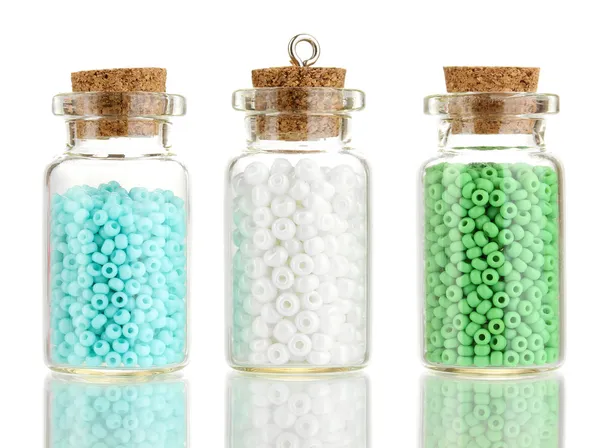 Petites bouteilles pleines de perles colorées isolées sur blanc — Photo