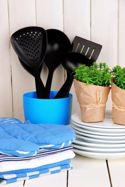 Ajustes de cocina: utensilios, agarraderas, toallas y más en la mesa de madera — Foto de Stock