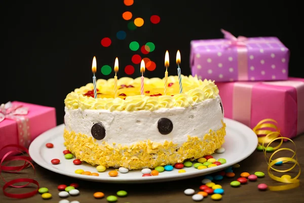 Happy birthday cake and gifts, on black background — Stock Photo, Image