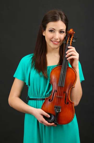 Vakker ung jente med fiolin på grå bakgrunn – stockfoto