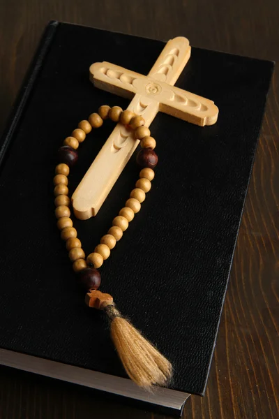 Bible, rosary and cross on wooden table close-up — Stock Photo, Image