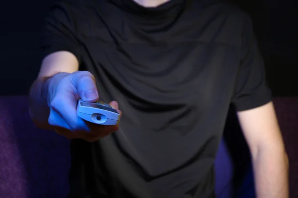 Man hand holding a TV remote control, on dark background — Stock Photo, Image