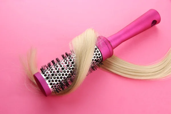 Comb brush with hair, on pink background — Stock Photo, Image