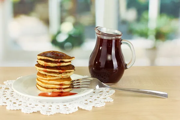 Frittelle dolci su piatto con marmellata su tavolo in cucina — Foto Stock