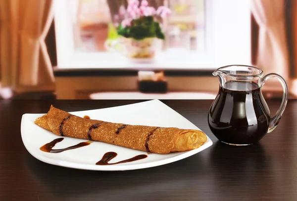 Panquecas doces na chapa com leite condensado na mesa no quarto — Fotografia de Stock