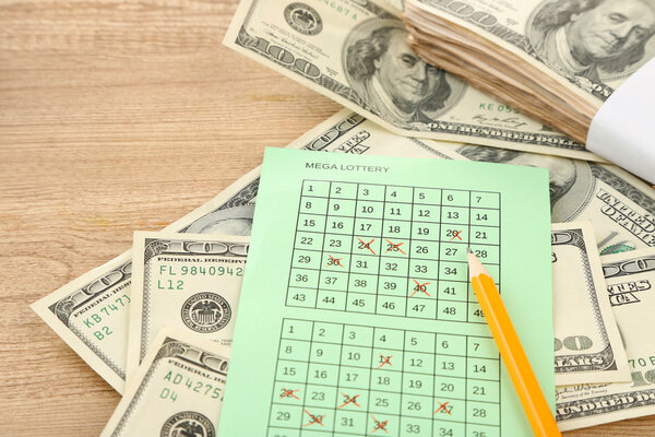 Lottery ticket,money and pencil on wooden background