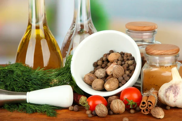 Composition of mortar, bottles with olive oil and vinegar, and green herbals, on bright background — Stock Photo, Image