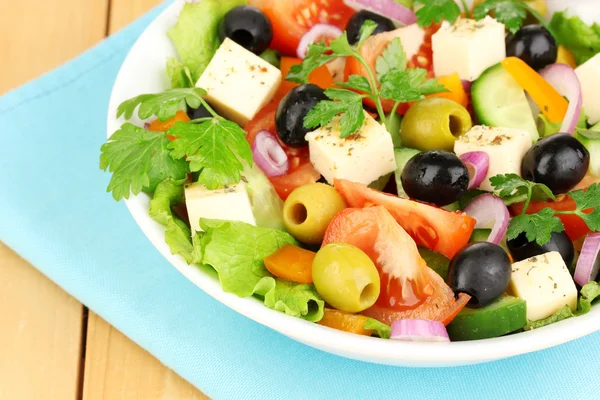 Frischer Salat im Teller auf Holztisch — Stockfoto