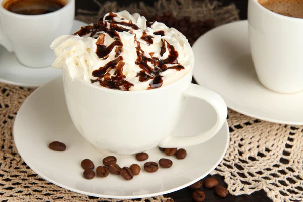 Cup of whipped cream coffee on wooden table close up — Stock Photo, Image