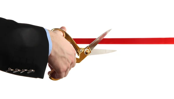 A mão do homem cortando fita vermelha com par de tesouras isoladas em branco — Fotografia de Stock
