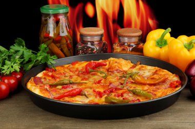 alev arka plan üzerinde sebze ile tavada lezzetli biberli pizza