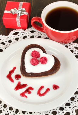 ahşap masa yakın çekim üzerinde kahve ile kalp şeklinde çikolata kurabiye