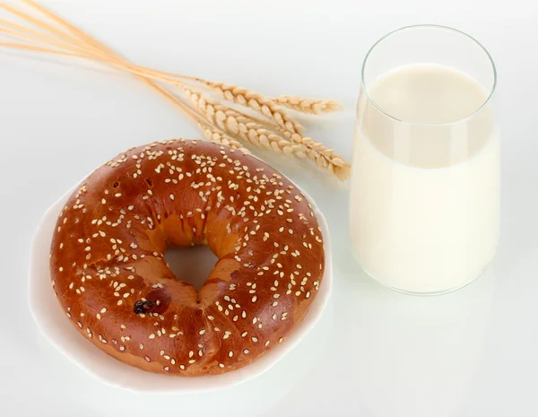 Rotolo di pane e vetro di latte isolato su bianco — Foto Stock