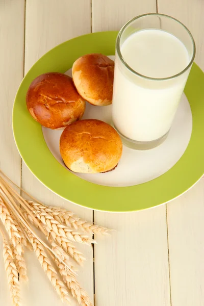 Bread rolls and glass of milk on wooden table — Stock Photo, Image
