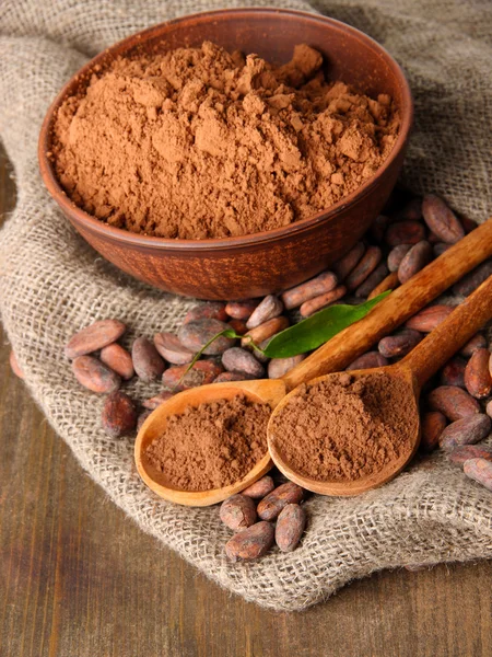 Cacao en polvo y granos de cacao sobre fondo de madera —  Fotos de Stock