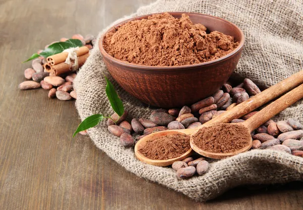 Cocoa powder and cocoa beans on wooden background — Stock Photo, Image