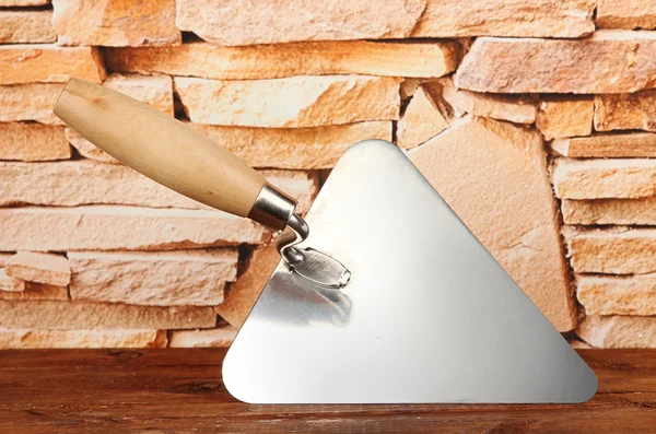 Metal tool for building on brick wall background — Stock Photo, Image