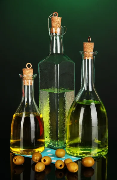 Original glass bottles with oil on dark color background — Stock Photo, Image