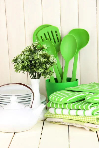 Kitchen settings: utensil, potholders, towels and else on wooden table — Stock Photo, Image