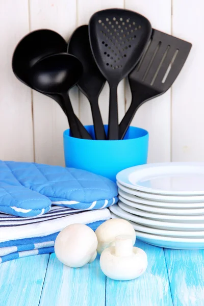 Configurações da cozinha: utensílio, pegadores de panela, toalhas e muito mais na mesa de madeira — Fotografia de Stock