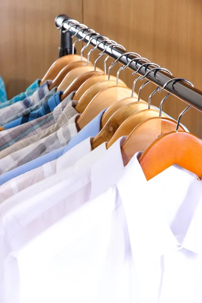 Men's shirts on hangers in wardrobe — Stock Photo, Image