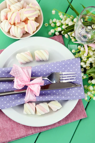 Tischdekoration in violetten und rosa Tönen auf farbigem Holzhintergrund — Stockfoto