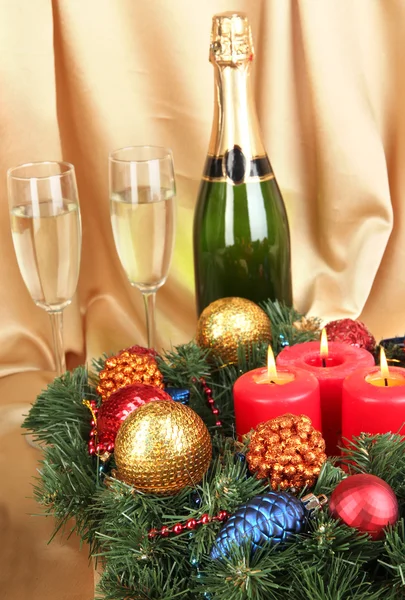Bela grinalda de Natal em composição com champanhe sobre fundo de tecido de ouro — Fotografia de Stock