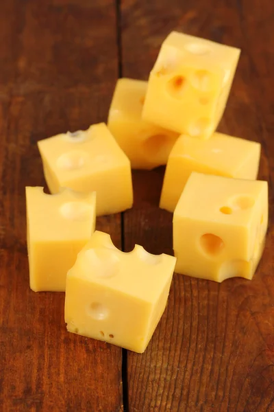 Cheese cubes on wooden table — Stock Photo, Image