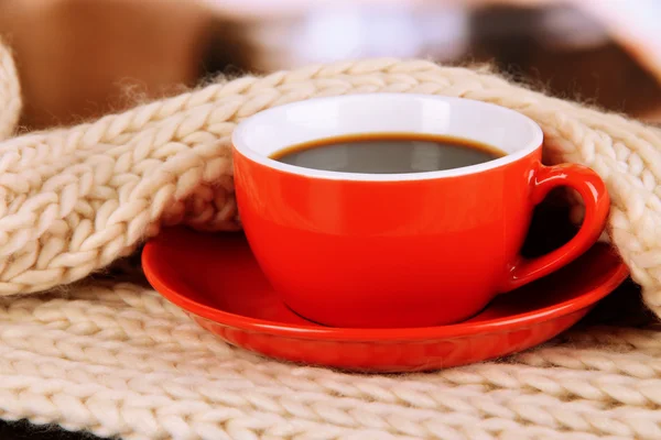 Tasse de café avec écharpe sur la table dans la chambre — Photo