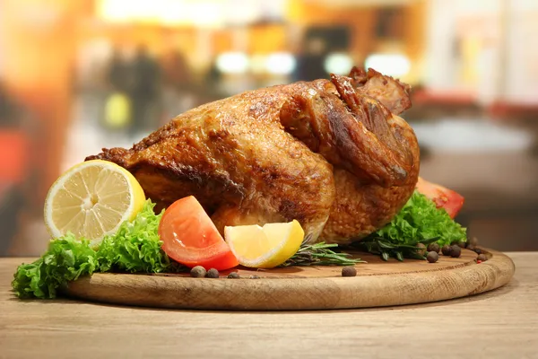 Pollo arrosto intero con verdure su piatto, su tavolo di legno in caffè — Foto Stock