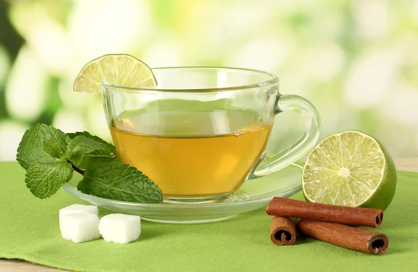 Cup of tea with mint,lime and cinnamon on table on bright background — Stock Photo, Image