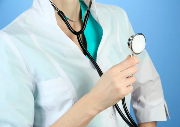 Medical doctor with stethoscope, on color background — Stock Photo, Image