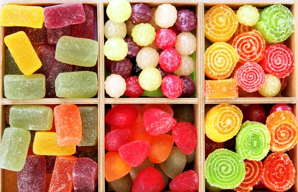 Caramelos multicolores en caja de madera, aislados en blanco — Foto de Stock